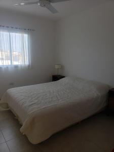 a white bed in a bedroom with a window at Luminoso dpto con wifi in San Luis