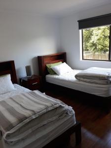 two beds in a room with a window at Honolulu Beach Escape in Smiths Beach