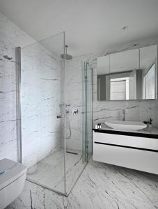 y baño blanco con lavabo y ducha. en Cool Bright Studio W Parking Poolviews! #238, en Estambul
