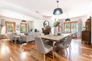 Una sala de estar con una mesa y sillas de madera. en Hahndorf Luxury Retreat 5 bedrooms for 12 guests, en Hahndorf