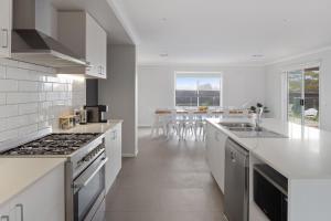 a kitchen with white appliances and a table with chairs at Coastal Grand On McKenzie in Cowes