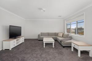 a living room with a couch and a flat screen tv at Coastal Grand On McKenzie in Cowes