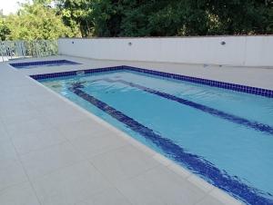 a swimming pool with blue tiles on the ground at Cantinho FW in Ubatuba