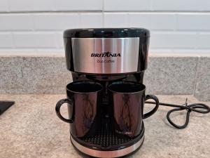 a coffee maker on a counter with two coffee mugs at Cantinho FW in Ubatuba