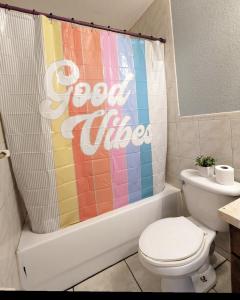 a bathroom with a toilet and a colorful shower curtain at MiLuSol in Miami