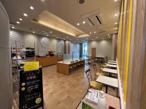 a dining room with tables and chairs and a cafeteria at Smile Hotel Nagano in Nagano