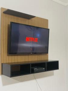 a flat screen tv sitting on a entertainment center at Kit Net Santa Cruz in Praia Grande