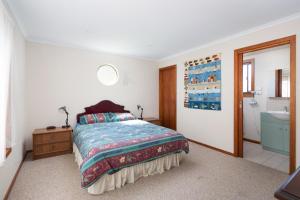 a bedroom with a bed and a bathroom with a sink at 64 San Remo Parade San Remo in San Remo