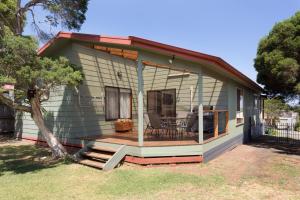 a small house with a deck and a table at 64 San Remo Parade San Remo in San Remo