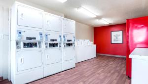 a laundry room with white washers and a red wall at Home 1 Suites Extended Stay in Montgomery