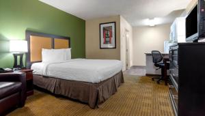 a hotel room with a bed and a flat screen tv at Home 1 Suites Extended Stay in Montgomery
