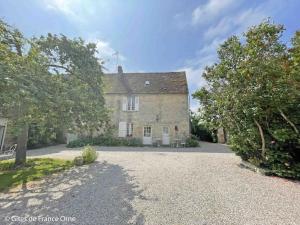 una vieja casa de piedra con árboles delante de ella en Gîte Sarceaux, 4 pièces, 6 personnes - FR-1-497-131, en Sarceaux