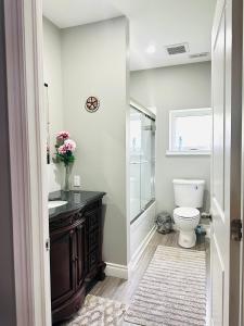 een badkamer met een toilet, een wastafel en een spiegel bij Cozy 3-bedroom farmhouse in wine-country in Niagara on the Lake