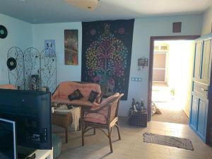 a living room with a chair and a tv at Maison du bonheur in El Harhoura