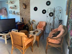 a living room with chairs and a table and a tv at Maison du bonheur in El Harhoura
