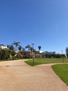 un parc avec des palmiers et un trottoir dans l'établissement Maison du bonheur, à Harhoura