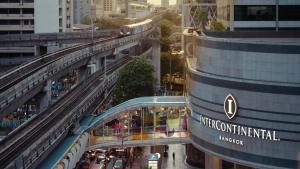 a train on an elevated track in a city at InterContinental Bangkok by IHG in Bangkok