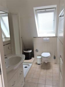 a bathroom with a sink and a toilet and a window at Beautiful Top Floor Apartment with Lake View in Lausanne