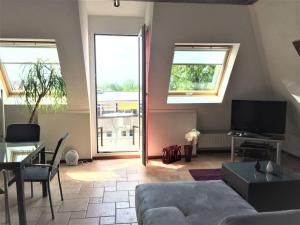 a living room with a couch and a tv at Beautiful Top Floor Apartment with Lake View in Lausanne