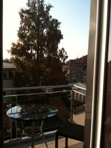 a table and chair on a balcony with a tree at Beautiful Top Floor Apartment with Lake View in Lausanne