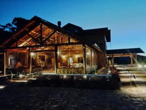 une maison en bois éclairée la nuit dans l'établissement Parque Nacional EcoResort, à Urubici