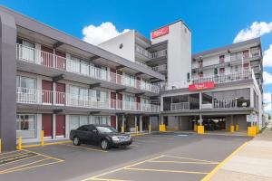 a car parked in a parking lot in front of a hotel at Red Roof PLUS & Suites Virginia Beach - Seaside in Virginia Beach