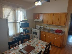 a kitchen with a table and a stove top oven at Crsytal Chateau Room Rental in Brooklyn