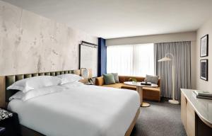 a hotel room with a large white bed and a chair at Kimpton Theta New York - Times Square by IHG in New York +107 photos