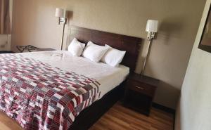 a hotel room with a bed and two lamps at Red Roof Inn Memphis - Airport in Memphis