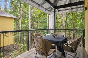 a patio with a table and chairs on a deck at Tamborine Mountain Glades in Mount Tamborine