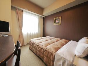 Habitación de hotel con cama y ventana en Hotel Route-Inn Ichinomiya Ekimae, en Ichinomiya