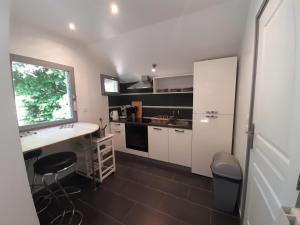a kitchen with white cabinets and a counter and a window at Gîte au calme avec jardin et WIFI à La Roche-Posay - FR-1-541-52 in La Roche-Posay