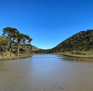 un fiume con alberi sul fianco di una montagna di Parque Nacional EcoResort a Urubici