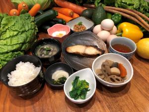 a table topped with bowls of different types of vegetables at Green Rich Hotel Izumo (Artificial hot spring Futamata Yunohana) in Izumo