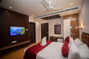 a bedroom with a bed with a tv on a wall at Hotel Silver Clé in Hyderabad