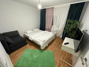 una pequeña sala de estar con cama y sofá en green apartment 38 berceni, en Bucarest