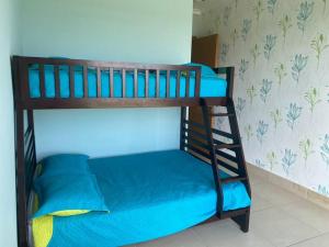Litera con sábanas azules y escalera en Lujoso y Familiar Apartamento de Playa y Golf en San Carlos Panamá en San Carlos