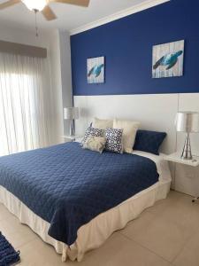 Dormitorio azul con cama y pared azul en Lujoso y Familiar Apartamento de Playa y Golf en San Carlos Panamá en San Carlos