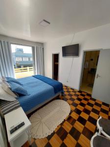 1 dormitorio con 1 cama y suelo a cuadros en Casa na praia em Florianópolis, en Florianópolis