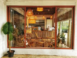 een groot glazen raam van een keuken met stoelen en tafels bij ริเวอร์บรีซ เชียงแสน River Breeze Chiangsean in Chiang Saen