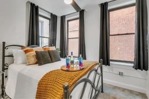 a bedroom with a bed with a table and windows at Urban Paradise in OTR - Beautiful New Condo In Historic Building With Downtown Views! condo in Cincinnati
