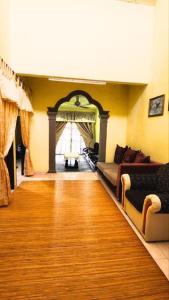 - un salon avec un canapé et du parquet dans l'établissement Mama Ija Homestay Islamic Arau, à Arau