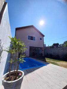 a villa with a swimming pool in front of a house at Chalé Penedo Charmosa in Penedo
