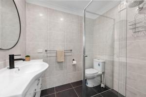 a bathroom with a shower and a sink and a toilet at Sea Breeze Two Bedroom Apartment in Redcliffe
