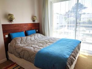 a bed in a bedroom with a large window at Duplex à 50m de la plage avec parking et 2 chambres - FR-1-368-391 in Trégastel