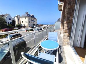 a balcony with a table and chairs and a street at Duplex à 50m de la plage avec parking et 2 chambres - FR-1-368-391 in Trégastel