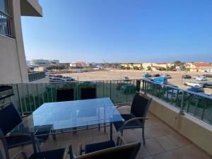 a balcony with a table and chairs and a parking lot at T3 Moderne 6p au bord de la mer, Le Barcarès, parking et terrasse - FR-1-81-593 in Le Barcarès