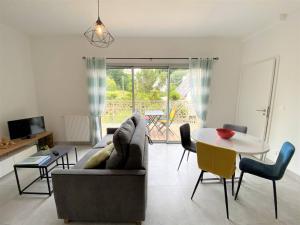 a living room with a couch and a table at Appartement neuf avec balcon, proche du port de Perros-Guirec - FR-1-368-392 in Perros-Guirec