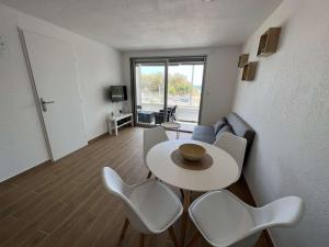 ein Wohnzimmer mit einem weißen Tisch und Stühlen in der Unterkunft Appartement Valras-Plage, 2 pièces, 4 personnes - FR-1-701-66 in Valras-Plage