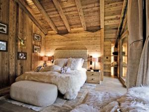 a bedroom with a large bed in a wooden room at Chalet Airelles - Luxe et Confort au Pied des Pistes avec SPA et Services de Conciergerie - FR-1-613-52 in Méribel